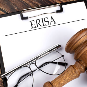 A judge's gavel and eyeglasses rest on a clipboard labeled 'ERISA', symbolizing ERISA claims in Florida. - CJ Henry Law Firm, PLLC.