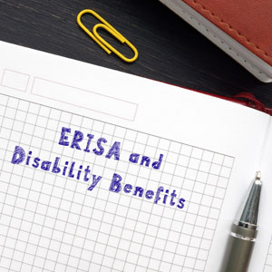 Notebook with 'ERISA and Disability Benefits' written on graph paper - CJ Henry Law Firm, PLLC